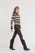 Load image into Gallery viewer, Read headed model wears a black and natural stripe crew neck with a pretty wave effect stripe.
